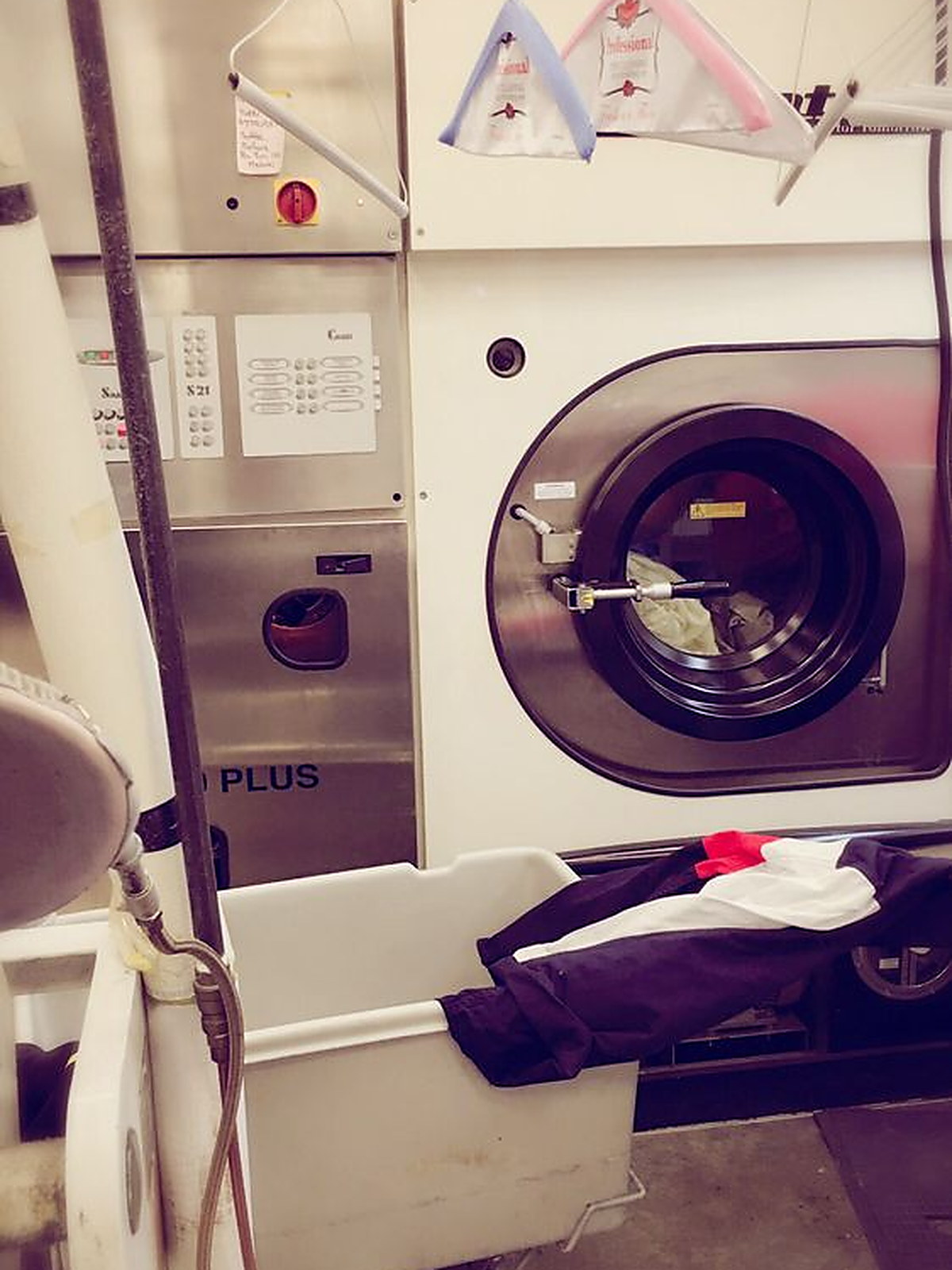 The dry cleaning machine in the shop's own plant, a loaded cart in front of the drum